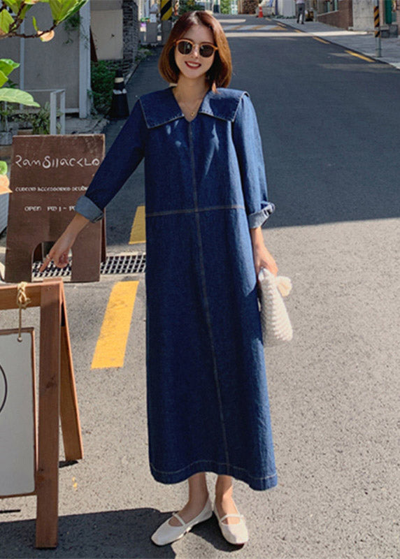 Fashionable denim patchwork dress with blue button accents, peter pan collar, and practical pockets, for a comfortable and stylish everyday look