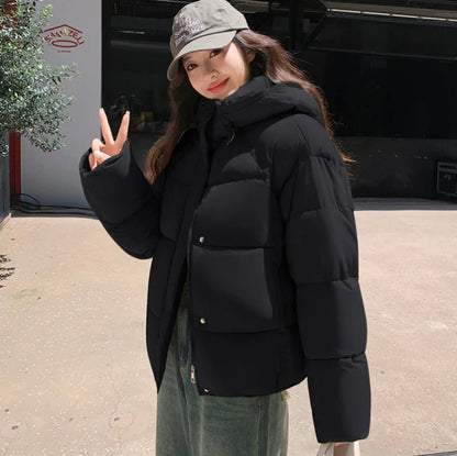 Elegant women's statement in a black puffer coat with a practical hat for a perfect style