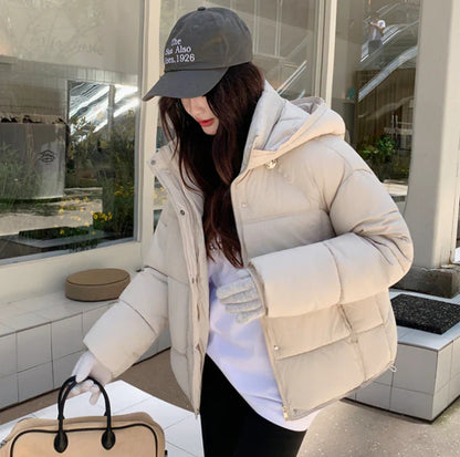 Elegant women's statement in a black puffer coat with a practical hat for a perfect style
